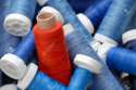 7248279-Concept-shot-with-a-heap-of-blue-bobbins-and-a-red-one-standing-out-Stock-Photo.jpg