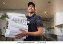 stock-photo-smiling-pizza-delivery-man-holding-many-pizza-boxes-in-a-commercial-kitchen-175403348.jpg