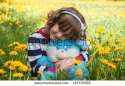 stock-photo-little-girl-with-blue-toy-hare-on-the-green-lawn-of-yellow-dandelions-192715508.jpg