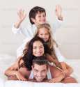 depositphotos_10311524-Happy-family-lying-on-their-bed.jpg