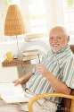 happy-pensioner-reading-home-16618118.jpg