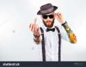 stock-photo-young-hipster-man-wearing-hat-suspenders-a-bow-tie-and-a-funny-tattoo-sleeve-showing-his-f-223161487.jpg