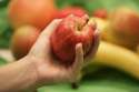 Food-hand-holding-apple-other-fruit-in-background.jpg