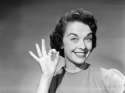 1950s-woman-smiling-wearing-pearl-necklace-making-okay-gesture-with-hand.jpg