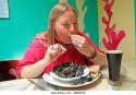 portrait-of-a-young-woman-eating-mussels-at-a-restaurant-dingle-co-bmmx39.jpg