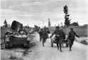 German troops from the 6th SS Division ,,nord´´ walking past soviet tanks.png