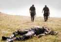 Two Bosnian Croat soldiers pass by the corpse of a Bosnian Serb soldier killed in the Croatian attack on the Serb-held town of Drvar, on August 18, 1995 in western Bosnia..jpg